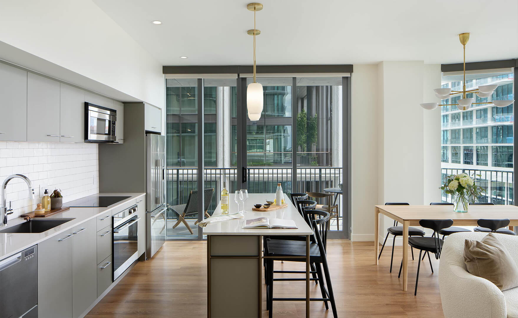 Open living space with kitchen and dining, looking towards large windows and balcony.
